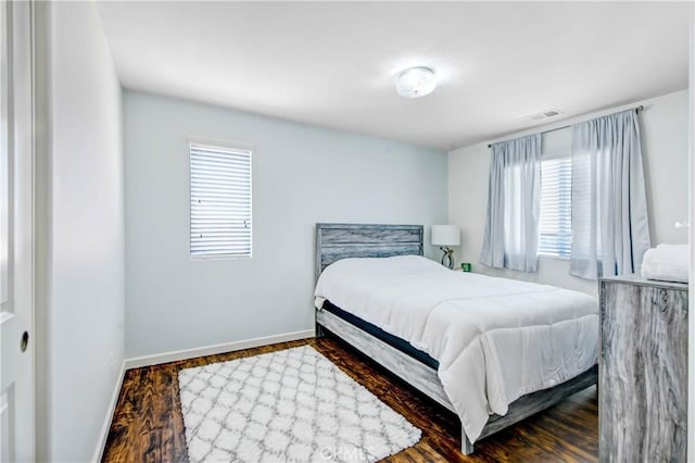 bedroom featuring dark hardwood / wood-style flooring and multiple windows