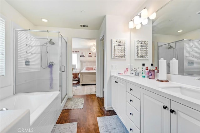 bathroom featuring hardwood / wood-style floors, vanity, and separate shower and tub