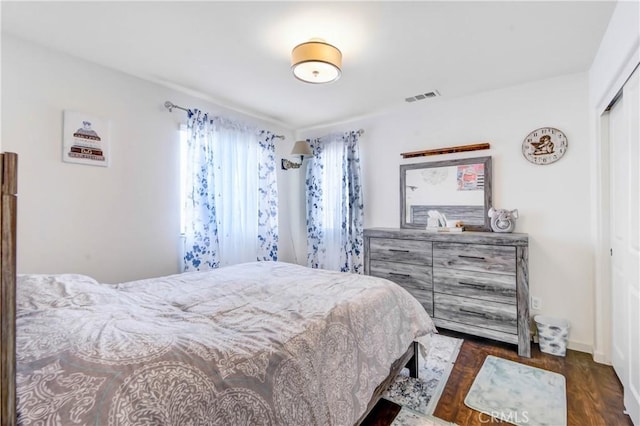 bedroom with dark hardwood / wood-style flooring and a closet