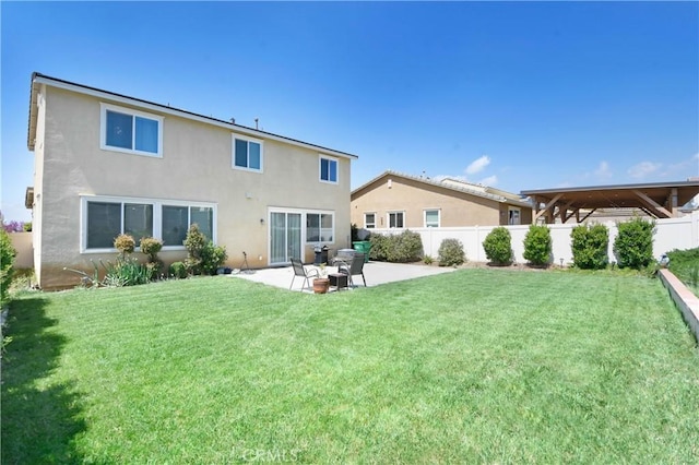 back of property with a yard and a patio