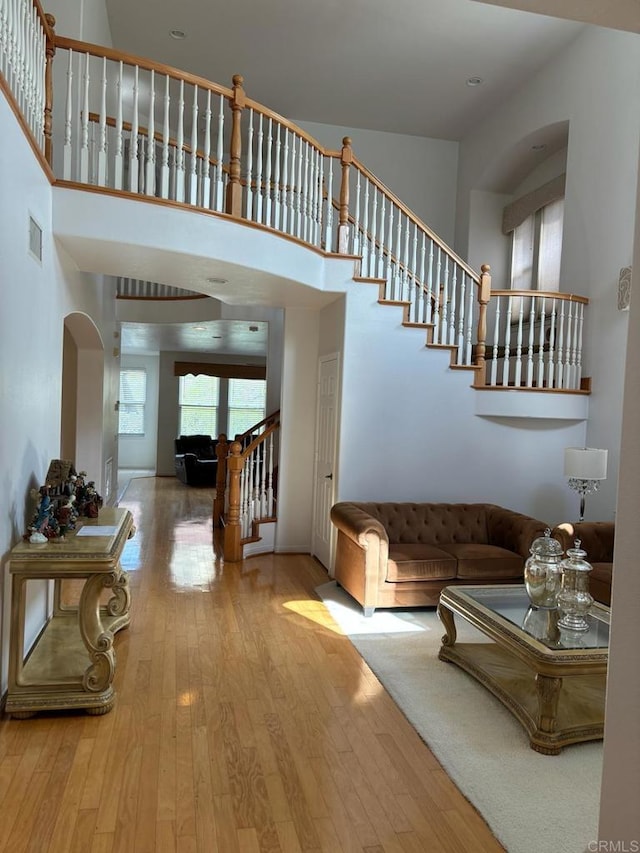 living room featuring a towering ceiling and hardwood / wood-style floors