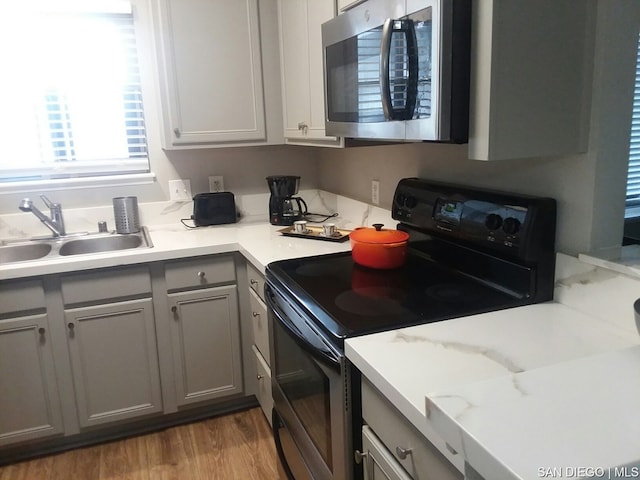 kitchen featuring gray cabinets, sink, electric range, and light wood-type flooring