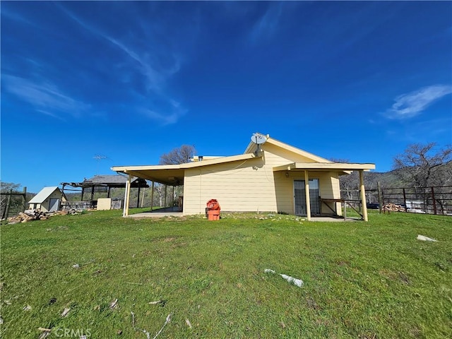 back of property featuring a patio area, fence, an attached carport, and a lawn