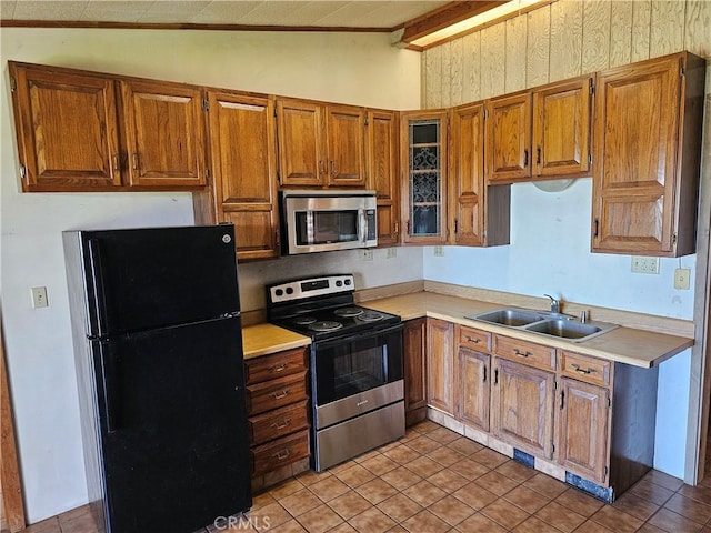 kitchen with vaulted ceiling with beams, light countertops, appliances with stainless steel finishes, and a sink