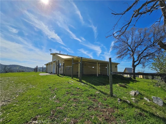 back of property featuring a lawn and a mountain view