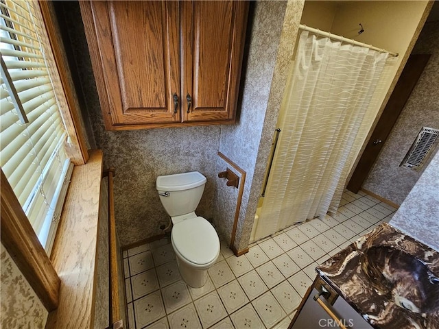 full bath with a wealth of natural light, visible vents, toilet, and wallpapered walls