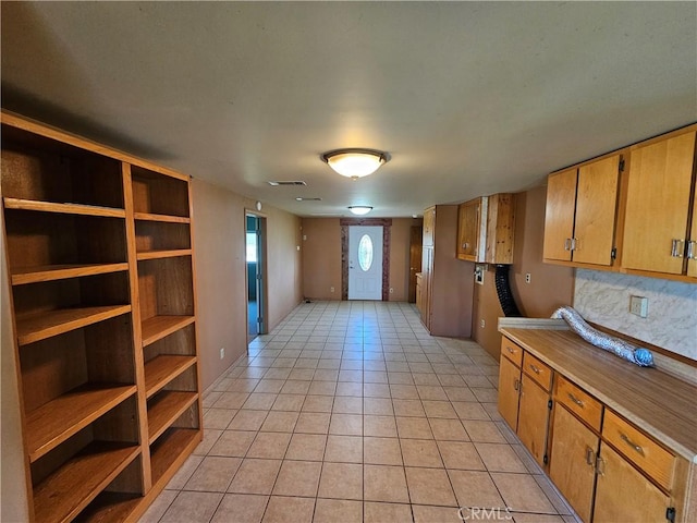 kitchen featuring visible vents, brown cabinets, light countertops, open shelves, and light tile patterned flooring