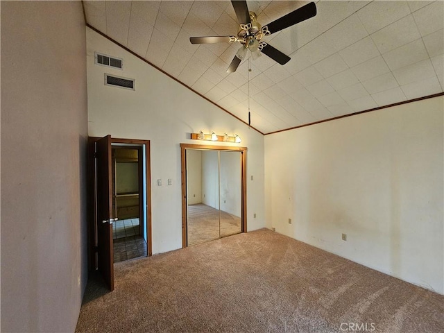 unfurnished bedroom with carpet floors, visible vents, vaulted ceiling, and ornamental molding