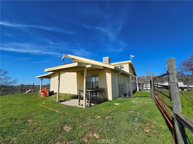 back of house with fence, a lawn, and a patio