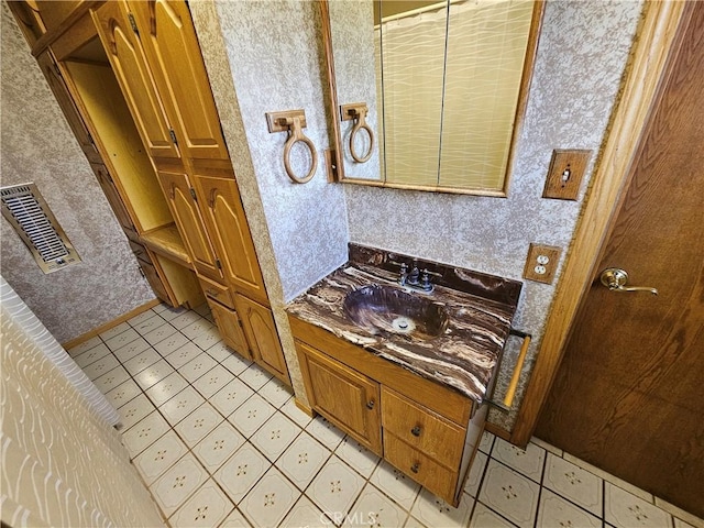 bathroom featuring vanity, visible vents, and wallpapered walls