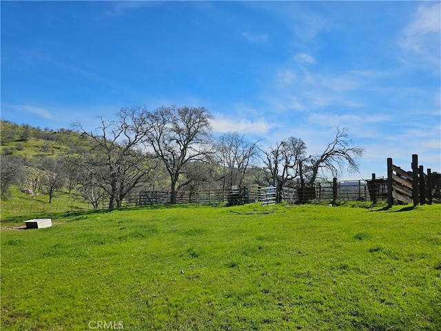 view of yard with a rural view and fence