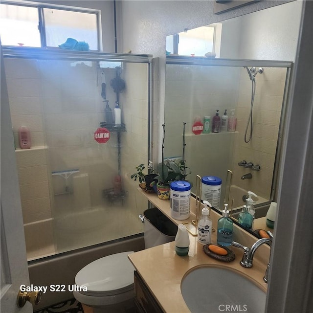 full bathroom with vanity, toilet, plenty of natural light, and enclosed tub / shower combo