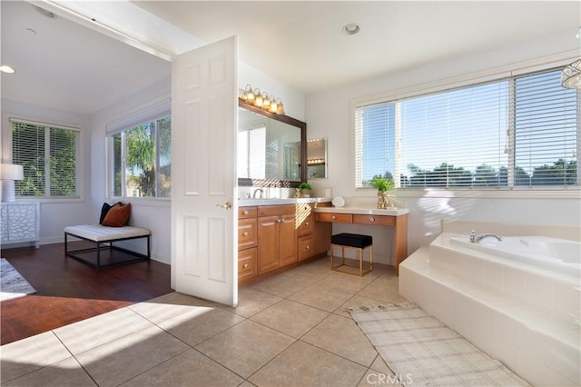 bathroom with vanity, tile patterned flooring, and tiled tub