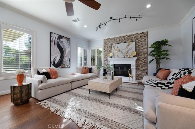 living room featuring dark wood-type flooring, plenty of natural light, and ornamental molding