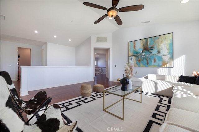 living room with vaulted ceiling, ceiling fan, and light wood-type flooring