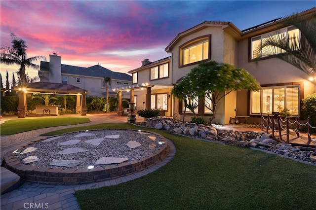 view of front of property featuring a lawn, a gazebo, a pergola, and a patio area