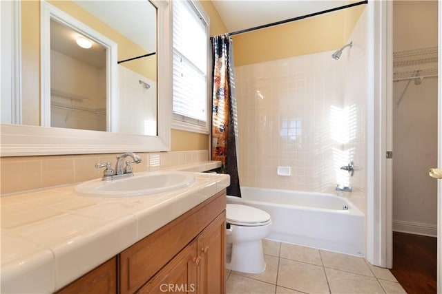 full bathroom with tile patterned floors, shower / bathtub combination with curtain, toilet, and vanity