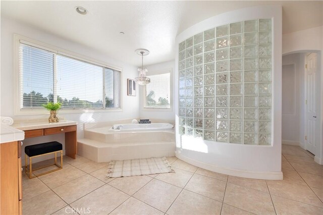 bathroom featuring a washtub, tile patterned floors, vanity, and an inviting chandelier