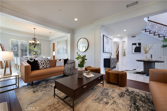 living room featuring light hardwood / wood-style flooring, crown molding, and an inviting chandelier