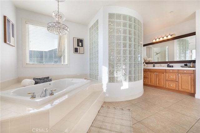 bathroom with vanity, a notable chandelier, tile patterned floors, and a relaxing tiled tub