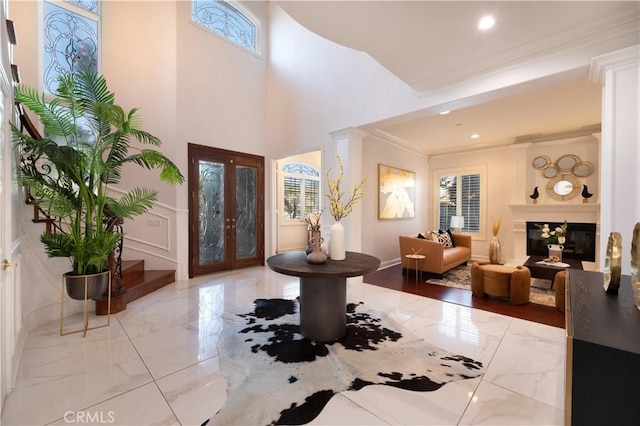 entrance foyer featuring plenty of natural light, crown molding, and french doors