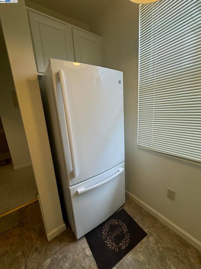 kitchen featuring white fridge and white cabinets