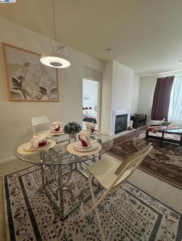 dining space with carpet flooring and a tile fireplace