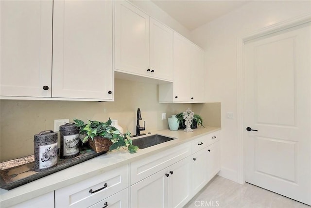 kitchen with white cabinetry and sink