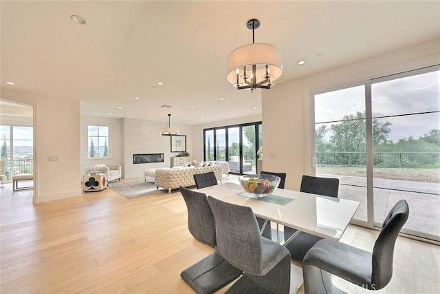 dining space featuring light wood-type flooring and a chandelier