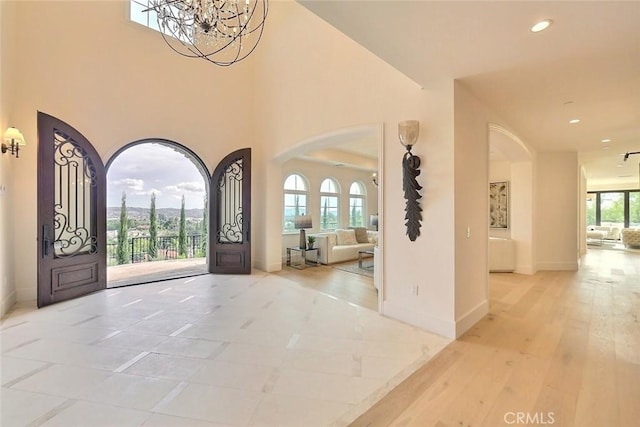 entrance foyer with an inviting chandelier, a wealth of natural light, and light hardwood / wood-style flooring