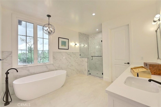 bathroom with vanity, tile walls, plus walk in shower, and an inviting chandelier