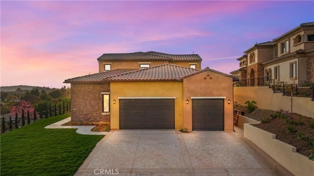 mediterranean / spanish house with a yard and a garage