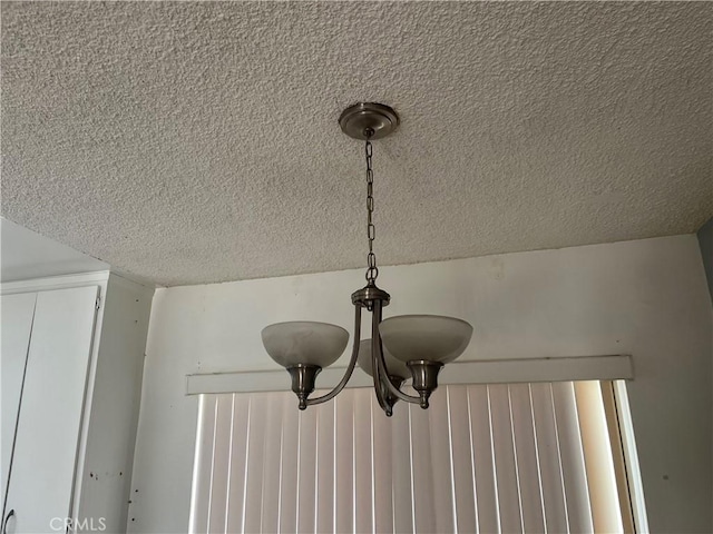 details with a chandelier and a textured ceiling