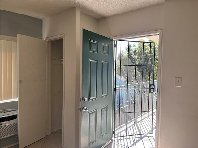 tiled foyer with a textured ceiling