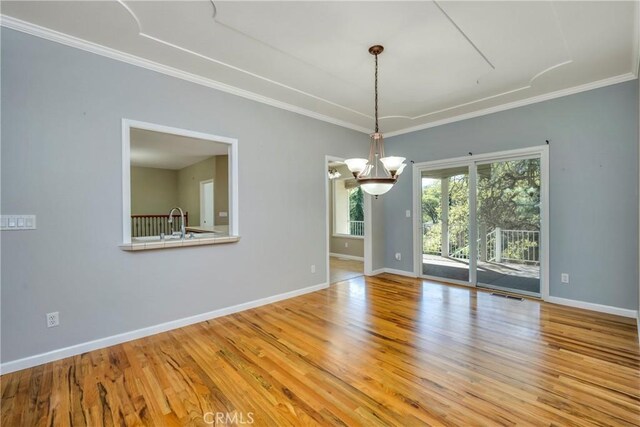 empty room with an inviting chandelier, ornamental molding, light hardwood / wood-style floors, and sink