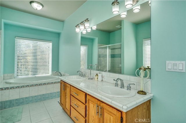 bathroom with a wealth of natural light, shower with separate bathtub, tile patterned floors, and vanity