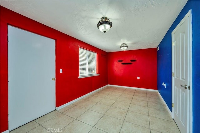 tiled spare room featuring a textured ceiling