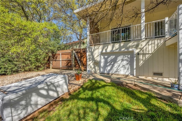 rear view of house with a garage and a balcony