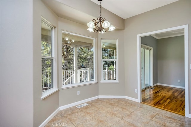 unfurnished dining area with a wealth of natural light, a notable chandelier, and light tile patterned flooring