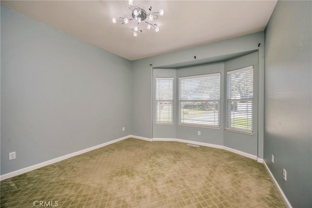 carpeted empty room with a notable chandelier