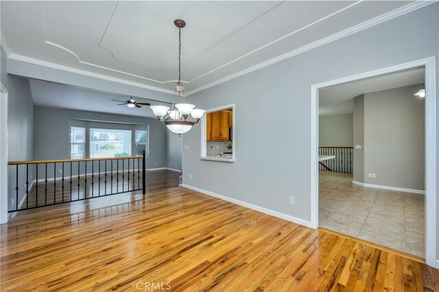 empty room with ceiling fan, light wood-type flooring, sink, and crown molding