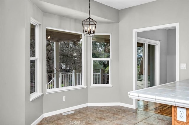 unfurnished dining area featuring a notable chandelier