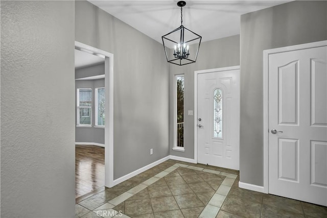 tiled foyer entrance with an inviting chandelier