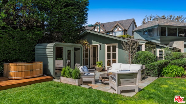 rear view of house with a patio area, outdoor lounge area, and a lawn