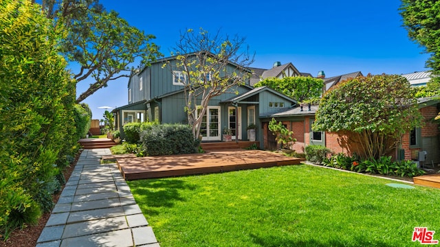 view of front facade featuring a wooden deck and a front lawn