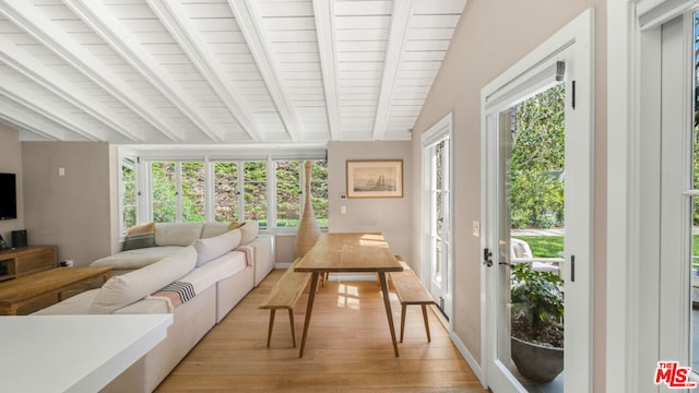 sunroom featuring vaulted ceiling with beams