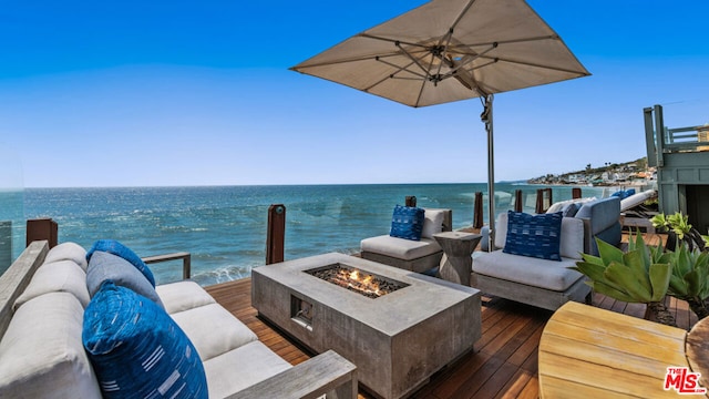 deck with a water view and a fire pit