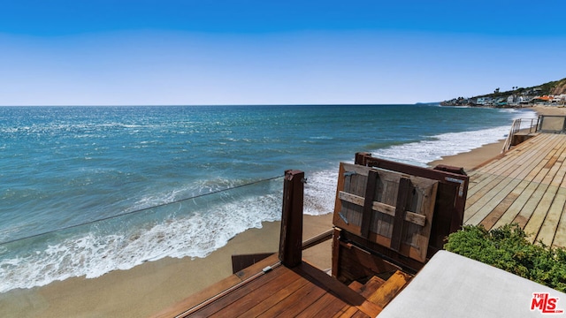 view of dock with a water view and a view of the beach