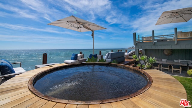 view of swimming pool with a water view and a hot tub