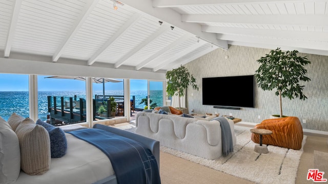 carpeted bedroom with lofted ceiling with beams, a water view, and rail lighting